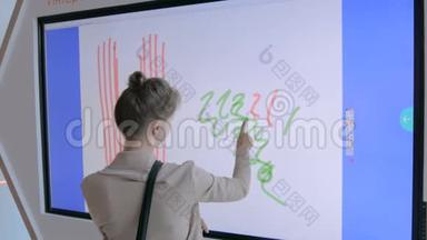使用互动触摸屏展会绘画的妇女